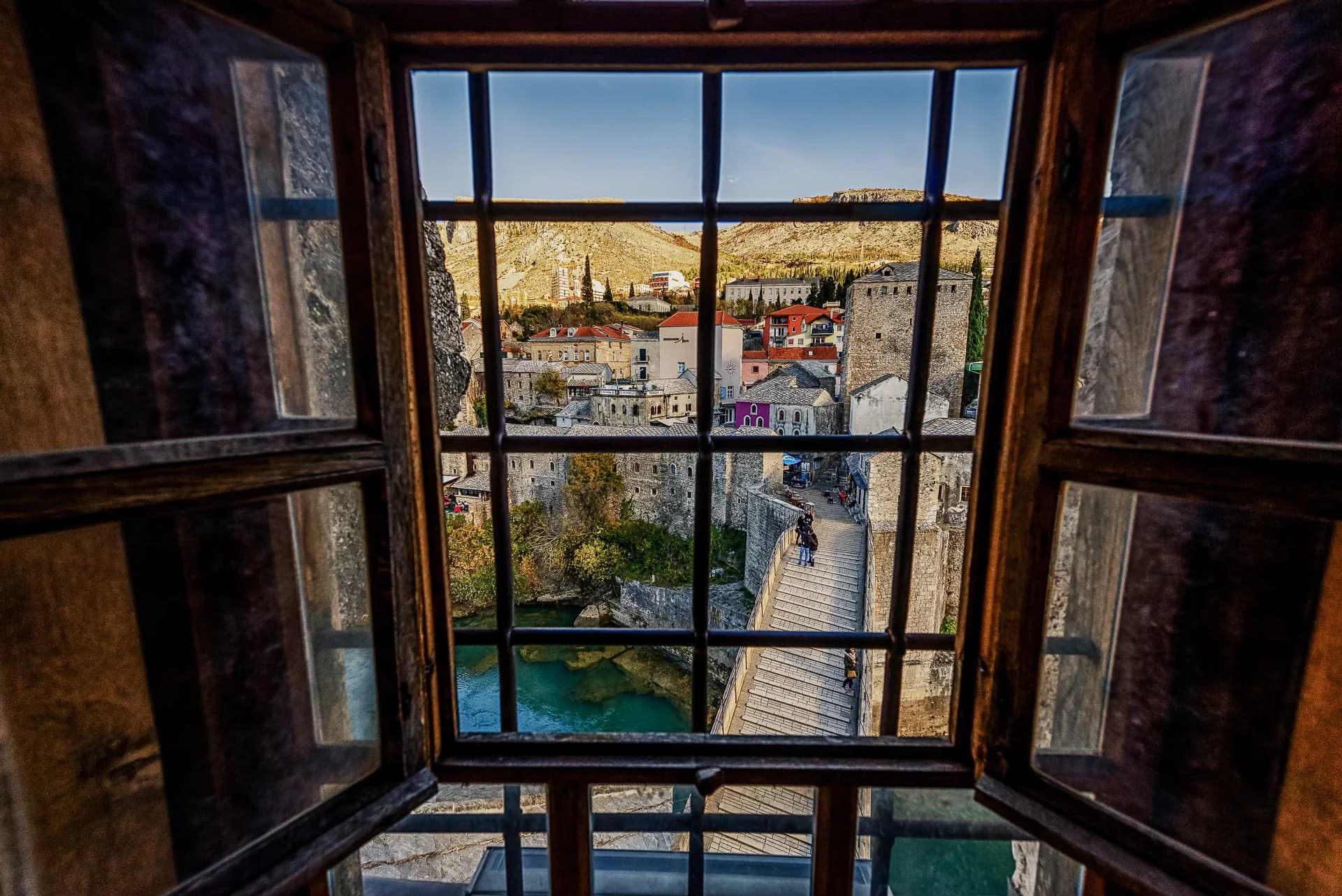 Udsigt til Stari Most i Mostar gennem et åbent trævindue